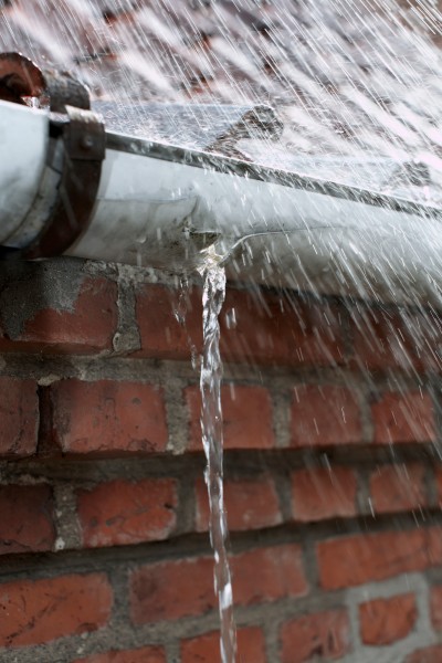 Starker-Wasserstrahl-laeuft-durch-defekte-Regenrinne